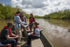 A group of people gather for a meeting on a boat.